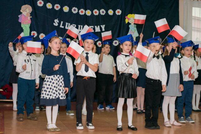 pierwszoklasiści z flagami Polski