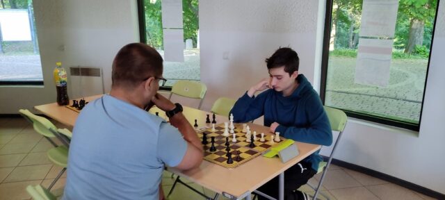 01. Uczestnicy siedzą przy stole i grają w szachy